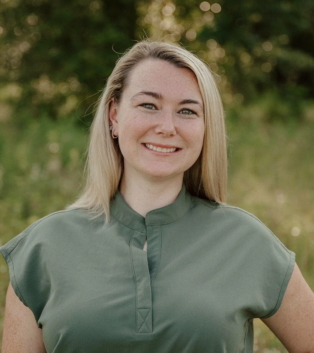 Female with long blonde hair wearing moss green scrubs